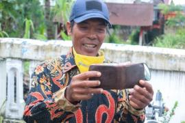 Salah Satu Warga Diberikan Dompet Milik Helmi Hasan Dan Seiisinya